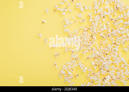Draufsicht auf knackiges Popcorn auf gelbem, Kino-Konzept verstreut Stockfoto