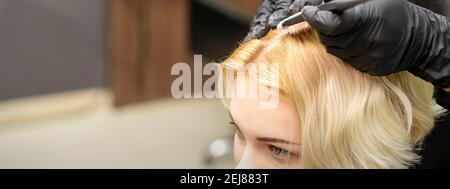 Ein Nahaufnahmekopf einer jungen blonden Frau, die färben wird Haare in einem Friseursalon Stockfoto