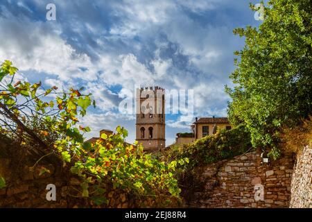 Assisi charmante mittelalterliche Altstadt mit dem alten Torre del Popolo (Volksturm) und stürmische Wolken darüber Stockfoto