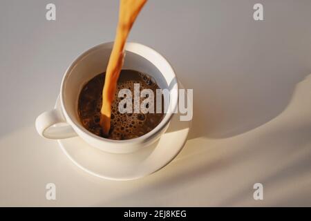 Gießen von Kaffee in einer Tasse schaffen Splash Stockfoto