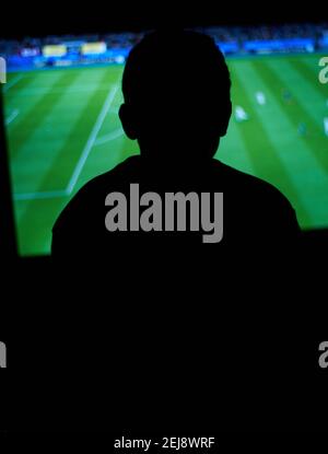 Junger Mann spielt Computerspiele im dunklen Raum. Stockfoto
