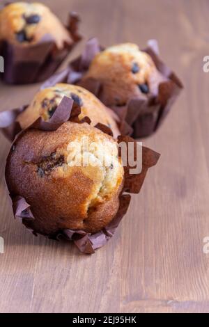 Nahaufnahme von Schokoladen-Muffins, mit selektivem Fokus, auf Holztisch, vertikal Stockfoto