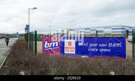 Rhyl, Denbighshire; Großbritannien: 21. Feb 2021: Ein Banner hat einen Countdown bis zum Eröffnungstag auf der Rückseite des Marina Quay Retail Park, wo B und M Schnäppchen geöffnet sind Stockfoto