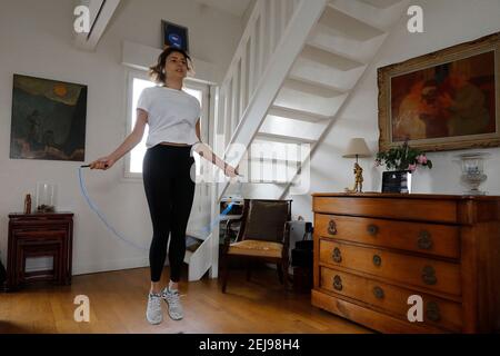 Junge Frau, die zu Hause während des Lockdown in montrouge, frankreich, trainiert Stockfoto