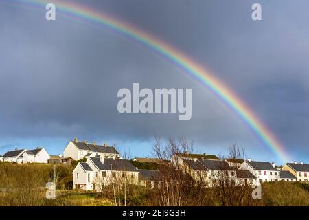 Ein Regenbogen erscheint über Sozialwohnungen, rathäusern, Terrasse in Ardara, County Donegal, Irland Stockfoto