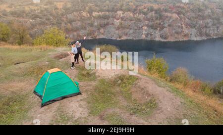 Luftaufnahme der Familie auf dem Campingplatz von oben, Eltern und Kind entspannen und Spaß haben in der Nähe Berge See, Familiencamp Urlaubskonzept Stockfoto