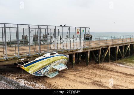 Verlassene Yacht 'Xanet' am Strand bei Shoeburyness Against Old verlassen Barge Pier Stockfoto