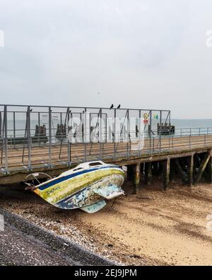 Verlassene Yacht 'Xanet' am Strand bei Shoeburyness Against Old verlassen Barge Pier Stockfoto