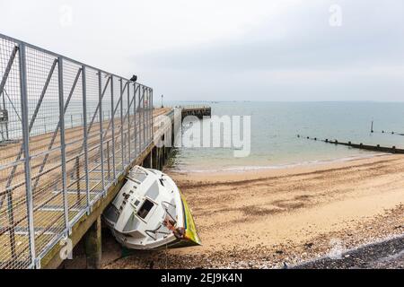 Verlassene Yacht 'Xanet' am Strand bei Shoeburyness Against Old verlassen Barge Pier Stockfoto