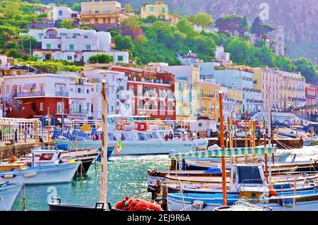 Landschaft der Insel, Blick vom Meer, mit weißen traditionellen mediterranen Häusern und bunten Booten auf dem Wasser im Vordergrund Stockfoto