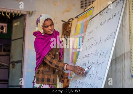 Uttar Pradesh. 05-15-2018.Frau unterrichtet mit einem Vorstand in der Schule. Frauen, die in der Textilindustrie mit Garn arbeiten. Frauen abgesehen von der Betreuung von Chi Stockfoto