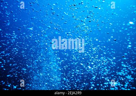 Wasser sprudelt über tiefblaue Hintergrundtextur Stockfoto