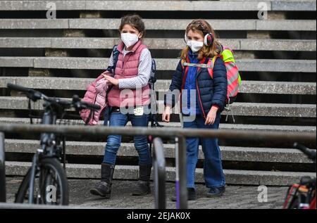 Frankfurt, Deutschland. Februar 2021, 22nd. Zwei Schüler verlassen ihre Grundschule nach der Klasse in Frankfurt, Deutschland, 22. Februar 2021. Nach lokalen Medien haben einige Schulen und Kindertagesstätten in Deutschland am Montag mit COVID-19 Präventionsmaßnahmen wieder eröffnet. Quelle: Lu Yang/Xinhua/Alamy Live News Stockfoto