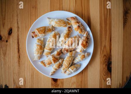 Frisch gebackene Croissants auf Holzbrett, Blick von oben Stockfoto