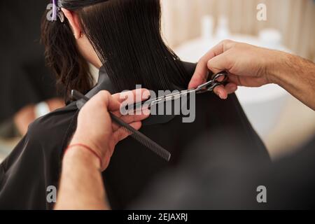 Coiffeur Hände mit einer Schere und einem Kamm Stockfoto