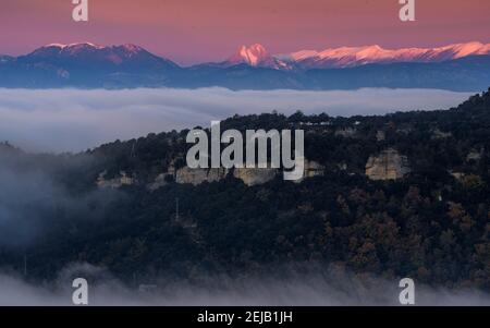 Sonnenaufgang über einem Wolkenmeer von den Aventic de Tavertet Cliffs aus gesehen. Im Hintergrund das Pedraforca-Massiv und die Pyrenäen (Collsacabra, Cataluña) Stockfoto