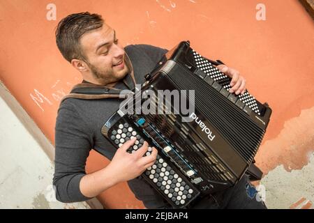 Ein Straßenmusiker spielt ein roland Akkordeon in einer Straße hinein Bologna Italien Stockfoto