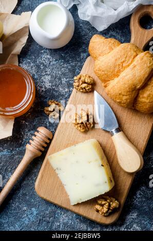 Verschiedene hausgemachte Stücke Käse mit Honig, Obst, Kekse und Nüsse auf dem Tisch. Frische Milchprodukte, gesunde Bio-Lebensmittel. Köstliche Vorspeise. Stockfoto