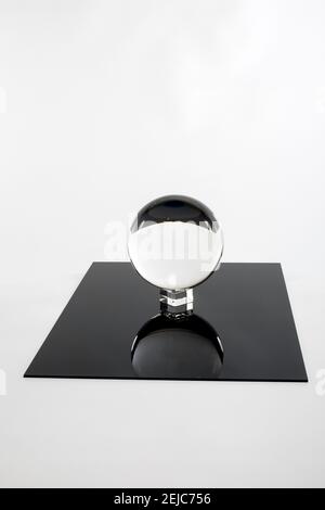 Kristallkugel auf einem schwarzen Spiegel. Stockfoto