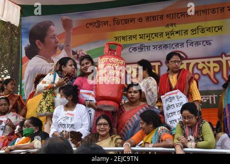 Kalkutta, Indien. Februar 2021, 22nd. Der Aktivist des All India Trinamool Congress (TMC) Mahila Morcha (Women Wing) hält eine Dummy-Kochgasflasche und Ghutes oder Kuhmist-Kuchen, um bei der Sit-in-Demonstration gegen steigende Kraftstoffpreise im ganzen Land zu protestieren. (Foto von Biswarup Ganguly/Pacific Press) Quelle: Pacific Press Media Production Corp./Alamy Live News Stockfoto