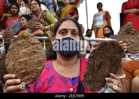 Kalkutta, Indien. Februar 2021, 22nd. Ein Aktivist des All India Trinamool Congress (TMC) Mahila Morcha (Women Wing) hält Ghutes oder Kuhmist-Kuchen, um bei der Sit-in-Demonstration gegen steigende Kraftstoffpreise im ganzen Land zu protestieren. (Foto von Biswarup Ganguly/Pacific Press) Quelle: Pacific Press Media Production Corp./Alamy Live News Stockfoto