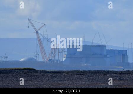 Burnham on Sea, Großbritannien. Februar 2021, 22nd. An einem warmen Tag in Burnham auf See über dem Meer kann Hinkley Point Kraftwerk, mit den höchsten Kräne der Welt, die Big Carl genannt werden gesehen werden. Bild: Robert Timoney/Alamy Live News Stockfoto