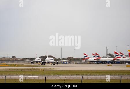 Zwei British Airways Airbus A320-232 Taxi vorbei an anderen geparkten. G-EUYY UND G-EUYL. G-EUYY hat Sharklet-Winglets eingebaut. Flughafen London Heathrow, London, Stockfoto