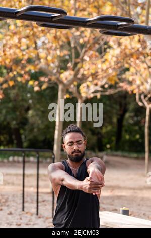 afroamerikanischer Kerl streckt nach einer Fitness, Calisthenics Sitzung in einem Park. Stockfoto