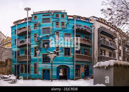 Der Platz der Elemente mit der Fassade eines blauen Gebäudes im Winter, der Platz mit Schnee bedeckt. Stockfoto