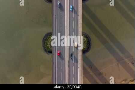 Blick von einer Drohne Blick auf den Verkehr auf einer Straßenbrücke über einen großen Fluss in Suffolk, Großbritannien Stockfoto