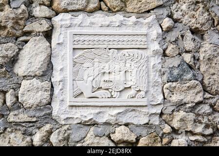 Bachtschissarai, Krim - 25. Januar 2021: Platte mit einem alten geschnitzten Relief, das einen Jagdlöwen darstellt, eingebettet in einen Steinzaun Stockfoto