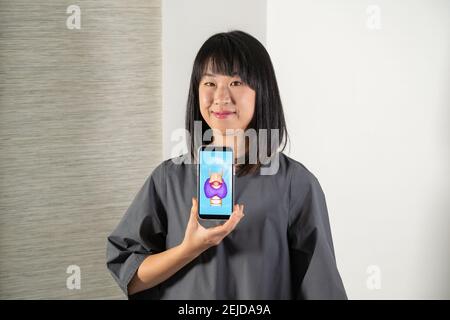 Frau hält Bildschirm mit Zeichnung der Schilddrüse und Kehlkopf Stockfoto