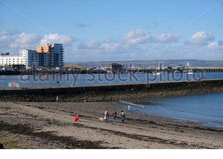 Edinburgh, Schottland, Großbritannien. Februar 2021, 22th. Menschen genießen Granton Hafen und Wellenbrecher, Blick von Wardie Bay an einem kalten und sonnigen Nachmittag. Kredit: Craig Brown/Alamy Live Nachrichten Stockfoto