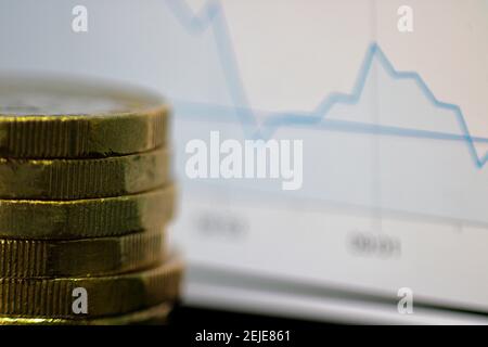 Makro Nahaufnahme eines Münzstapels und Finanzwesen Marktdiagramm Kurve im Hintergrund verschwommen Stockfoto