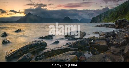 Felsige Küste von Loch Scavaig mit Cuillin Bergen bei Sonnenuntergang, Isle of Skye, Schottland Stockfoto