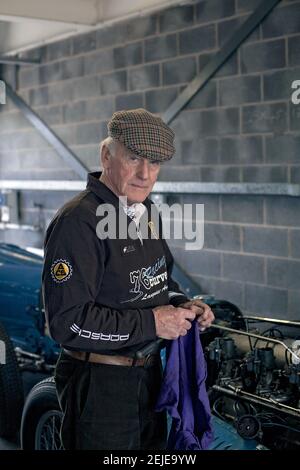 Ein älterer Mann, der sich die Hände putzte, nachdem er sein Oldtimer in der Garage gewartet hatte. Stockfoto