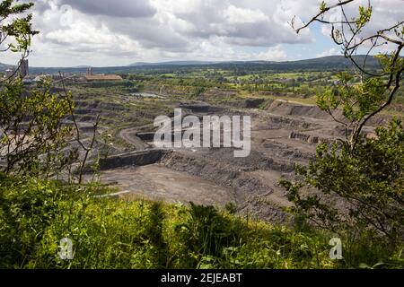 Großer Kalksteinbruch in Clitheroe, Ribble Valley. Bagger und Lastwagen arbeiten, um Felsen auszugraben Stockfoto