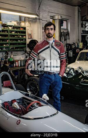 Racer Holding Helm in garage Stockfoto