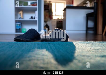 Blaue Filzschuhe zu Hause vor dem Teppich Stockfoto