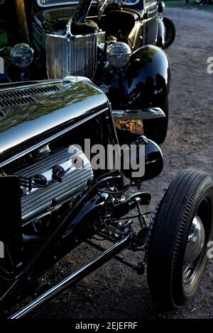 Schwarz glänzende Oldtimer geparkt bei der Hotrod Hayride, während Sonnenuntergang , Heathfield, Großbritannien. Stockfoto