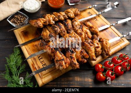 Hähnchenflügel auf Spieße auf Holzhintergrund gekocht Stockfoto