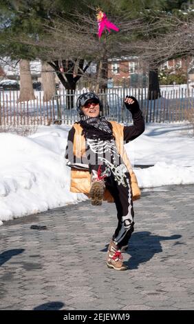 Eine chinesische amerikanische junge Dame spielt jianzi und trägt ein ungewöhnliches Outfit. In einem Park in Flushing Queens, New York. Stockfoto