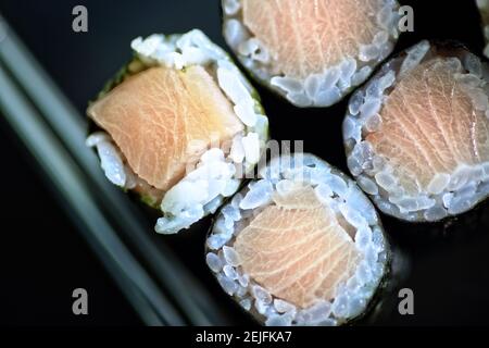 Köstliches Sushi-Set auf einem Teller mit Essstäbchen Stockfoto