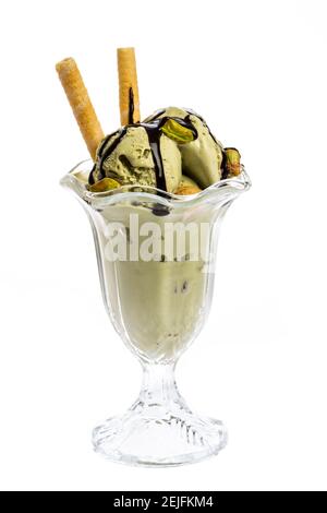 Eine Tasse Pistazien-Eis mit Schokoladensauce gekrönt Und Kegel Stockfoto