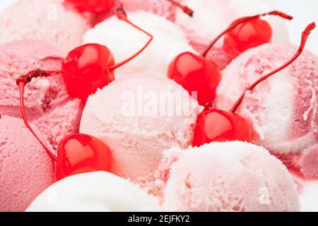 Kirschen zwischen vielen weißen und roten Eisschaufeln Stockfoto