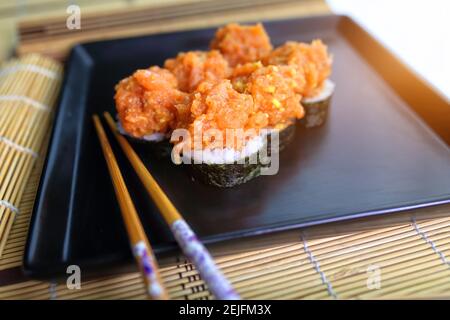 Fischtartare werden in Form von Sushi serviert Stockfoto