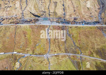 Glen Croe, Arrochar, Schottland, Großbritannien. Februar 2021, 22. Luftaufnahme von Erdrutschpräventivarbeiten zu A83 in Ruhe und sei dankbar Pass in Glen Croe. Die wichtige Route wurde von Erdrutschen geplagt, die oft die Hauptfahrbahn A83 gesperrt haben und den Verkehr dazu zwingen, die einspurige alte Militärstraße unten zu benutzen. Die letzten Erdrutsche haben diese Straße sogar blockiert. Derzeit wird der Verkehr in Konvois einbahnig begleitet. PIC; A83 oben und Old Military Road unten. Iain Masterton/Alamy Live News Stockfoto