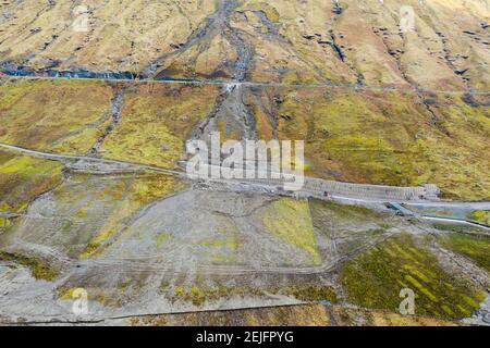 Glen Croe, Arrochar, Schottland, Großbritannien. Februar 2021, 22. Luftaufnahme von Erdrutschpräventivarbeiten zu A83 in Ruhe und sei dankbar Pass in Glen Croe. Die wichtige Route wurde von Erdrutschen geplagt, die oft die Hauptfahrbahn A83 gesperrt haben und den Verkehr dazu zwingen, die untere eingleisige Old Military Road unten zu benutzen. Die letzten Erdrutsche haben diese Straße sogar blockiert. Derzeit wird der Verkehr in Konvois einbahnig begleitet. Abb.; Allgemeine Ansicht mit der Größe des Schmutzflusses. Iain Masterton/Alamy Live News Stockfoto