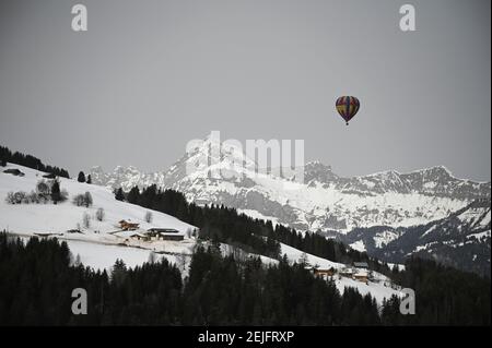 Crest Voland, Frankreich. Februar 2021, 22nd. Ein Heißluftballon fliegt vor einem Berg, dem Mont Charvin. Auch ohne Skilifte können Touristen die Pisten während der Absperrung nutzen. Skigebiete bieten verschiedene Aktivitäten wie Langlaufen, Schneeschuhwandern oder Heißluftballonfahrten. Quelle: Lisa Ducret/dpa/Alamy Live News Stockfoto