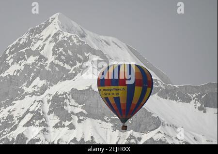 Crest Voland, Frankreich. Februar 2021, 22nd. Ein Heißluftballon fliegt vor einem Berg, dem Mont Charvin. Auch ohne Skilifte können Touristen die Pisten während der Absperrung nutzen. Skigebiete bieten verschiedene Aktivitäten wie Langlaufen, Schneeschuhwandern oder Heißluftballonfahrten. Quelle: Lisa Ducret/dpa/Alamy Live News Stockfoto